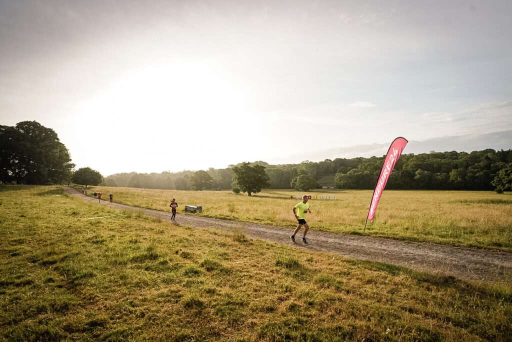 Solo runners head along a gravel trail as the sun sets behind them